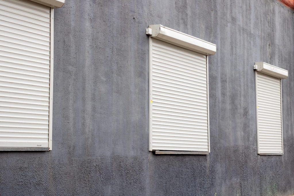 un-obturador-blanco-esta-actualmente-descansando-en-una-superficie-de-pared-gris